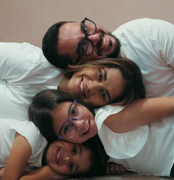 Happy family of four cuddling together, capturing love and joy.