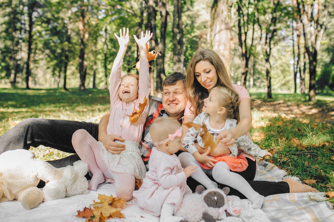 Family enjoying a sunny day with children in a park, bonding and having fun.